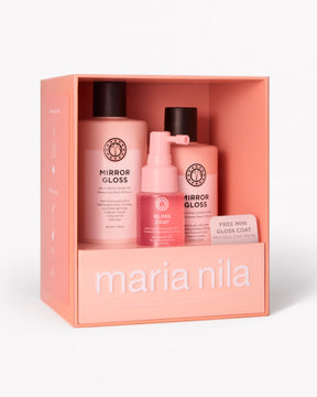 Maria Nila haircare gift set in a peach-colored box, containing two Mirror Gloss bottles, and a Gloss Coat pump bottle, on a white background.